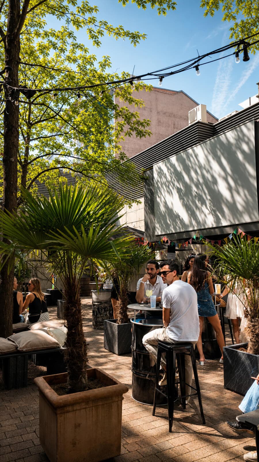 Palmen Garten Bar mit LED-Wand und Fassbar-Tischen